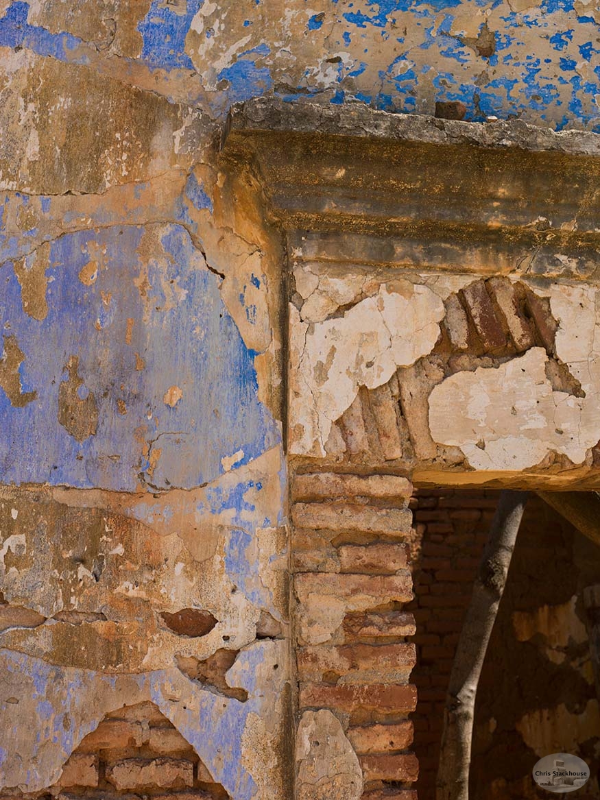 Crumbling parging revealing very old clay brickwork